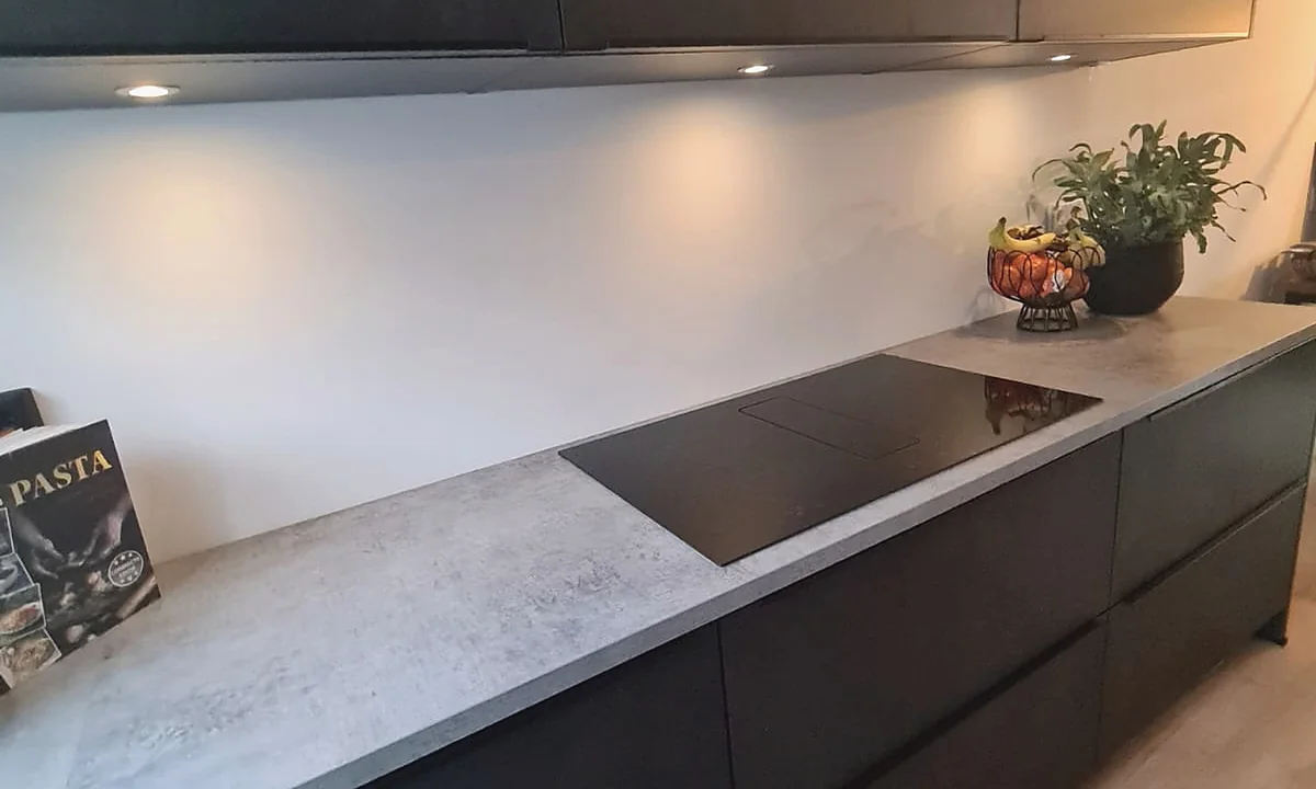 Strakke zwarte wand met betonlook blad